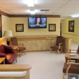 A waiting room with chairs and a television mounted on the wall.