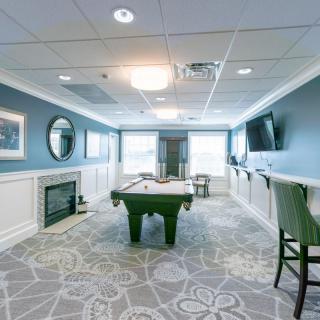 A stylish game room featuring a pool table, fireplace, and seating area.