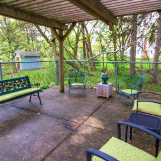 A cozy patio area with seating surrounded by lush greenery.