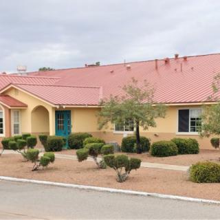 A suburban house with a red roof and desert landscaping.