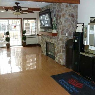 A clean and well-decorated lobby area featuring a stone fireplace and mounted television.