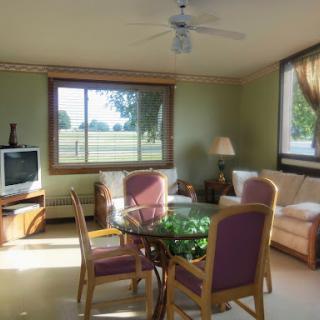 A cozy living room with a scenic view, featuring a glass dining table and comfortable seating.