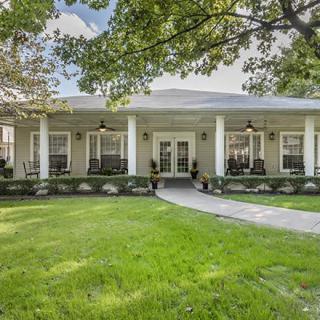 A charming home with a welcoming porch and lush green lawn.