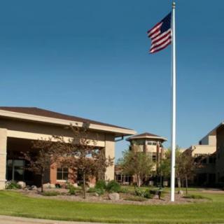 An outdoor scene featuring a building and an American flag waving on a tall pole.