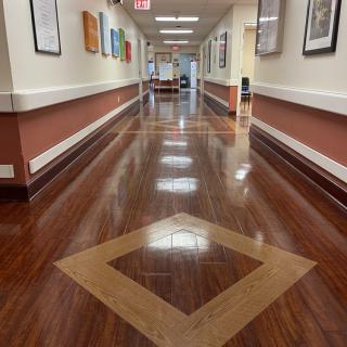 A clean and polished hospital hallway with artwork on the walls.