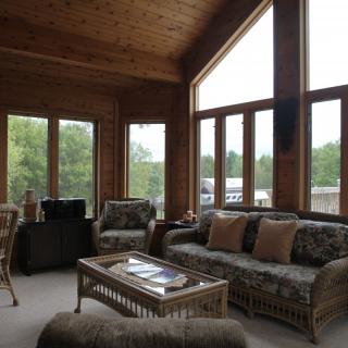 A cozy living room with large windows and comfortable seating.