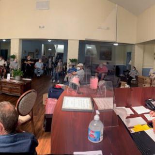 A group of people attending a meeting in a conference room setting.