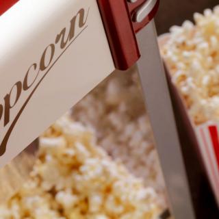 A close-up of a popcorn machine filled with freshly popped popcorn.