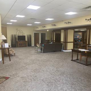 A spacious lobby with seating and tables, featuring comfortable furniture and neutral decor.