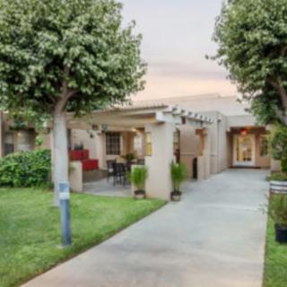 A charming residential home with a welcoming patio and lush green garden.