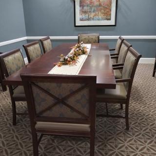 A neatly arranged dining room with a wooden table, chairs, and decorative centerpiece.