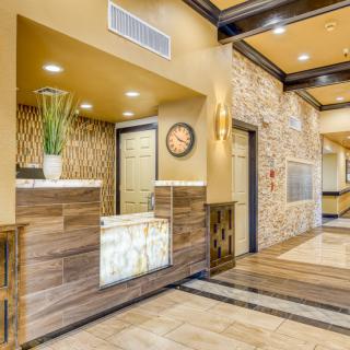 A modern hotel lobby featuring a reception desk with elegant interior design elements.