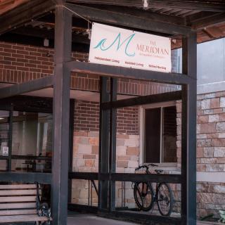 Entrance with a bicycle parked near glass doors and visible signage.
