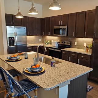 A modern kitchen with an island and stainless steel appliances.