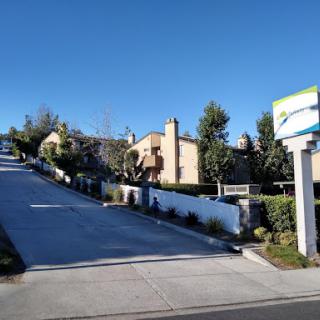 A serene residential area with houses nestled on a hillside under a clear blue sky.