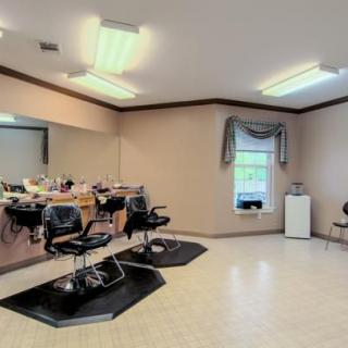 A spacious hair salon interior with styling stations and chairs.
