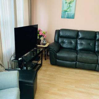 A cozy living room with a TV, leather sofa, and elegant decor.