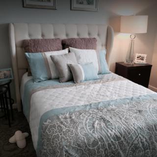 A cozy and well-decorated bedroom with a neatly arranged bed and soft lighting.