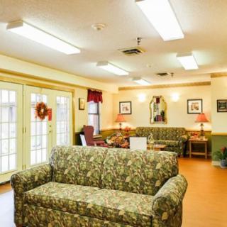 A cozy living room with patterned couches and warm lighting.