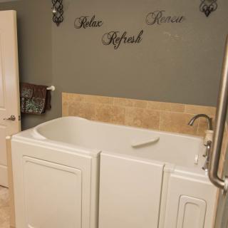 A bathroom featuring a walk-in bathtub with safety rails.