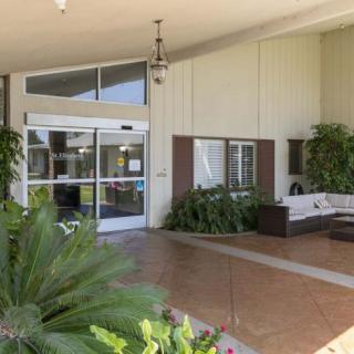 The entrance of a building with a seating area and plants.