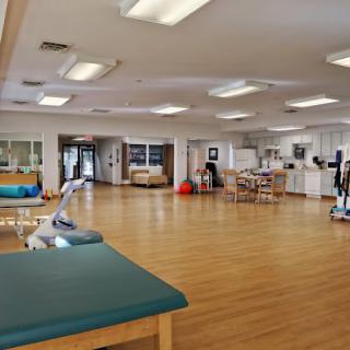 A spacious physical therapy room equipped with various exercise and rehabilitation tools.