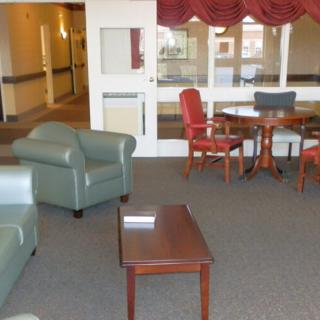 A cozy lobby area with chairs and a table.