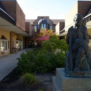 A courtyard with a statue and surrounding architecture.