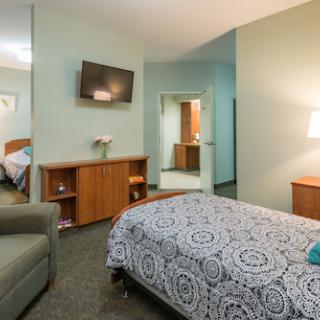 A cozy and well-furnished hotel room with modern amenities.
