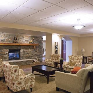 A cozy living room with a stone fireplace and comfortable seating arrangements.