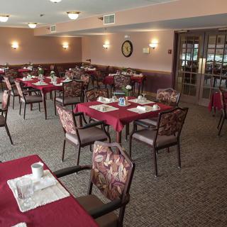 An empty dining room with neatly set tables and chairs, ready for guests.