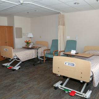A hospital room with two beds and accompanying medical equipment.