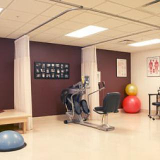 A well-equipped gym room featuring exercise machines and fitness balls.