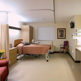 A clean and well-lit hospital room equipped with a bed and medical furniture.