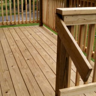 A wooden outdoor deck with railings.