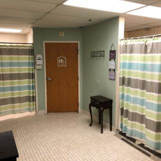 A calm and organized waiting area in a medical facility, featuring striped curtains and a wooden table.