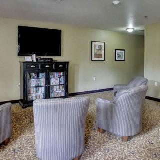 A modern lounge area with comfortable chairs and a wall-mounted television.