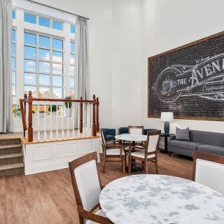 A bright living space with large windows, comfortable seating, and decorative chalkboard art.