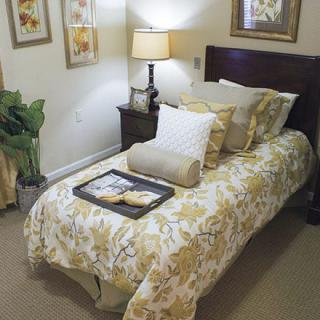 A cozy and elegantly decorated bedroom with floral bedding and soft lighting.