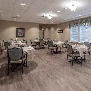 An empty dining room with neatly arranged tables and chairs.