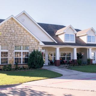 A spacious suburban house with a stone facade and a welcoming front porch.