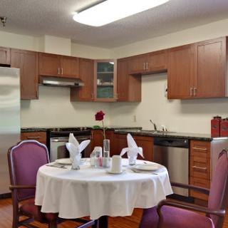 A modern kitchen and dining area featuring a round table elegantly set for a meal.