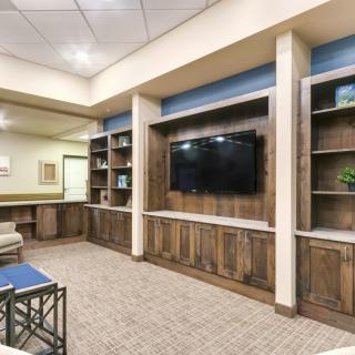 Modern living room setup with a large television and built-in shelving.
