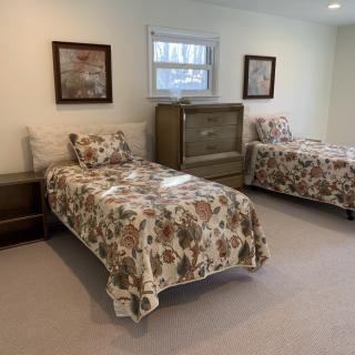 A cozy bedroom featuring twin beds with floral bedding and vintage furniture.