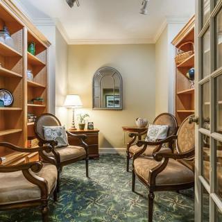 A cozy sitting area with armchairs and bookshelves.
