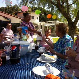 A family gathering outdoors with food, drinks, and festive decorations.