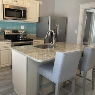 A modern kitchen featuring stainless steel appliances and a stylish island with bar stools.