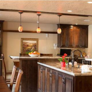 A warmly lit kitchen featuring wooden cabinets and a spacious countertop.
