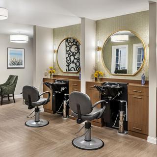 A modern beauty salon with stylish hair styling stations and large mirrors.
