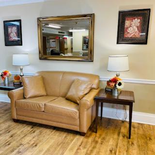 A cozy living room setup featuring a leather sofa, decorative artwork, and warm lighting.
